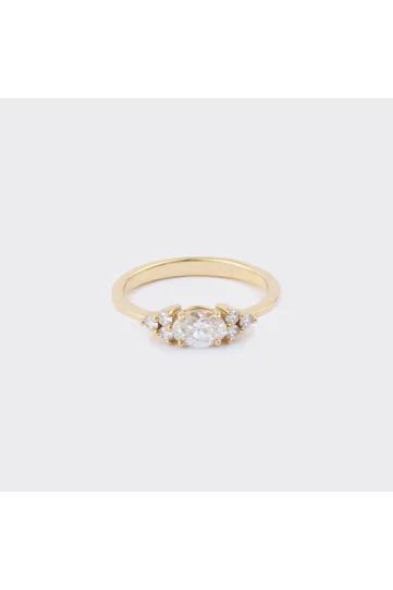 The Kenza M ring in 18k yellow gold set with an oval-cut diamond and accompanied by brilliant-cut diamonds.